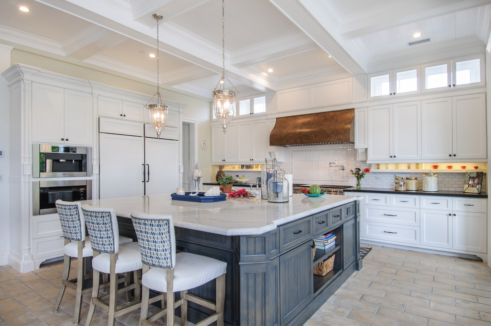 Photo of a beach style l-shaped kitchen in Los Angeles with shaker cabinets, white cabinets, white splashback, panelled appliances and with island.