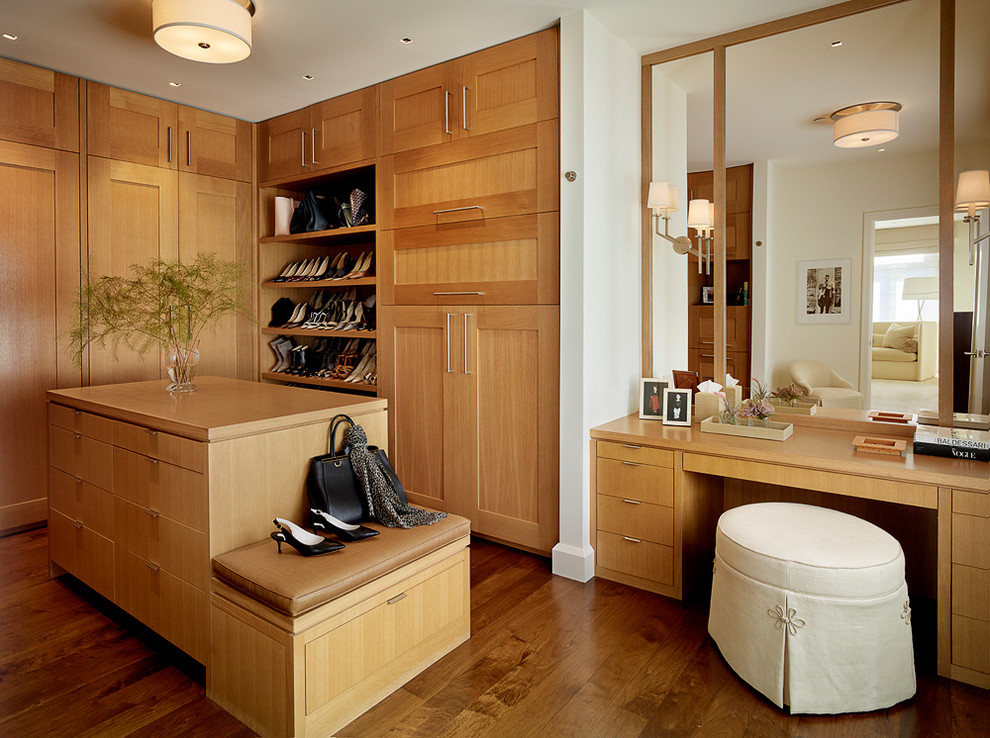This is an example of a large transitional women's dressing room in San Francisco with medium wood cabinets, dark hardwood floors, shaker cabinets and brown floor.