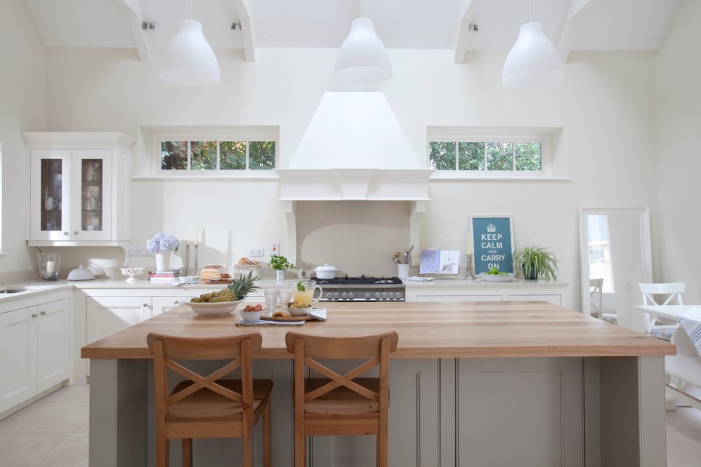 Inspiration for a traditional kitchen in Dublin with recessed-panel cabinets, white cabinets and wood benchtops.