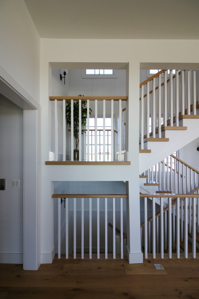 Cette photo montre un escalier nature en U de taille moyenne avec des marches en bois, des contremarches en bois, un garde-corps en bois et du lambris de bois.