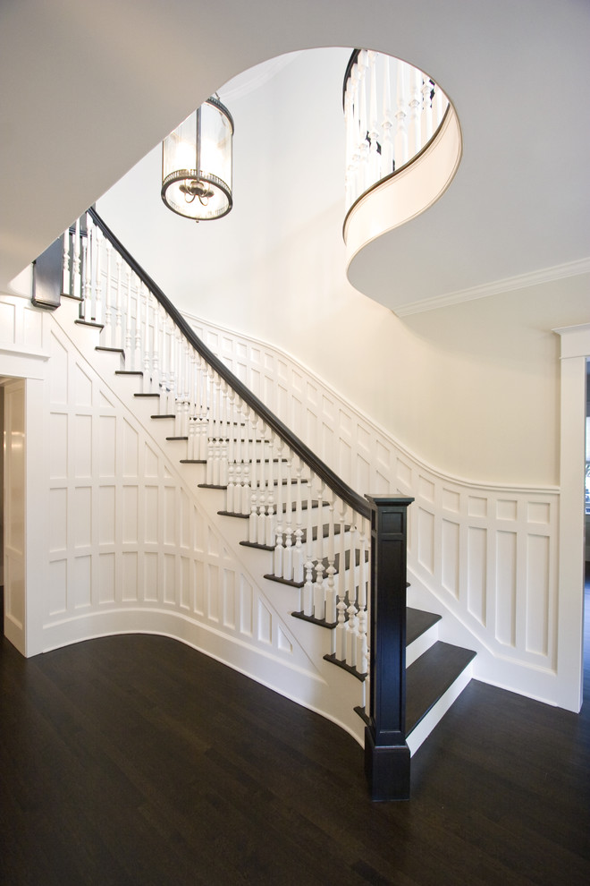 Design ideas for a large traditional wood curved staircase in New York with painted wood risers and wood railing.