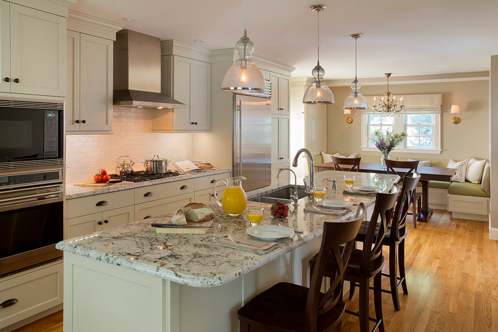 Photo of a traditional eat-in kitchen in Boston with an undermount sink, shaker cabinets, white cabinets, granite benchtops, beige splashback, ceramic splashback and stainless steel appliances.