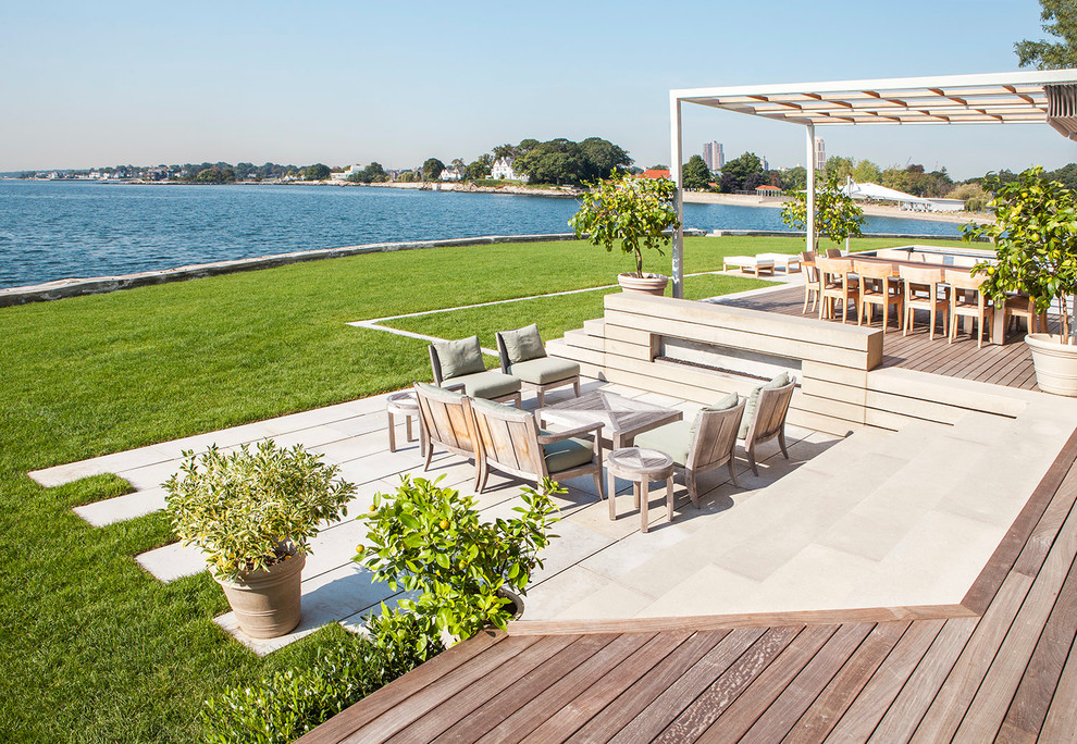 This is an example of a large beach style deck in New York with a pergola.