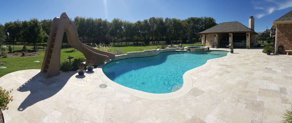 Photo of a large modern backyard custom-shaped natural pool in Dallas with a water slide and decking.