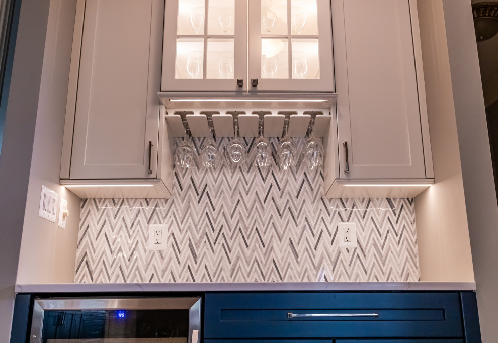 Example of a large transitional u-shaped medium tone wood floor and brown floor eat-in kitchen design in Baltimore with a farmhouse sink, shaker cabinets, blue cabinets, quartz countertops, white backsplash, marble backsplash, stainless steel appliances, an island and white countertops