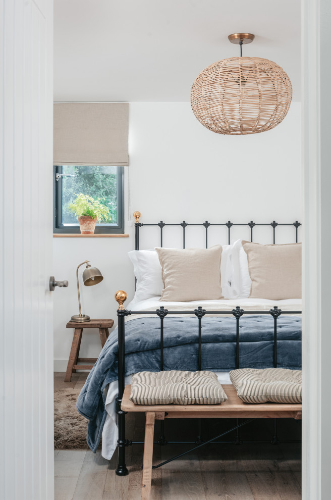 Landhaus Hauptschlafzimmer mit weißer Wandfarbe und braunem Holzboden in Cornwall