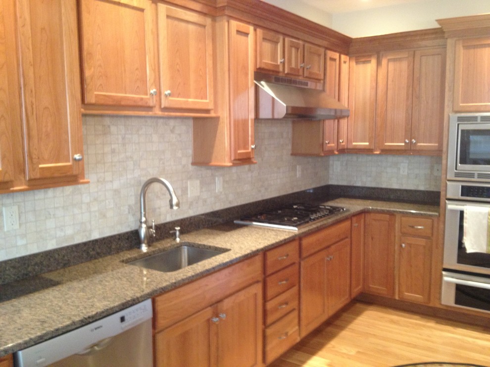 Inspiration for a transitional l-shaped vinyl floor eat-in kitchen remodel in Boston with a single-bowl sink, recessed-panel cabinets, light wood cabinets, granite countertops, beige backsplash, stone tile backsplash, stainless steel appliances and no island