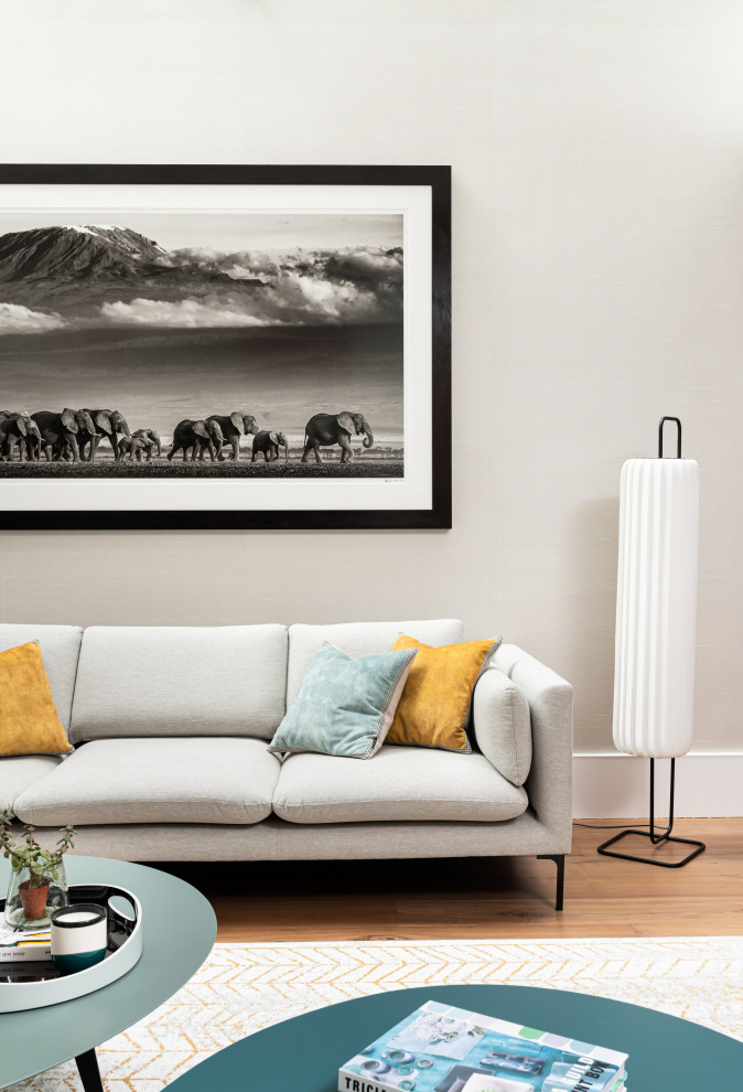 Imagen de salón para visitas abierto actual grande con paredes beige, suelo de madera en tonos medios, televisor colgado en la pared, suelo marrón y papel pintado