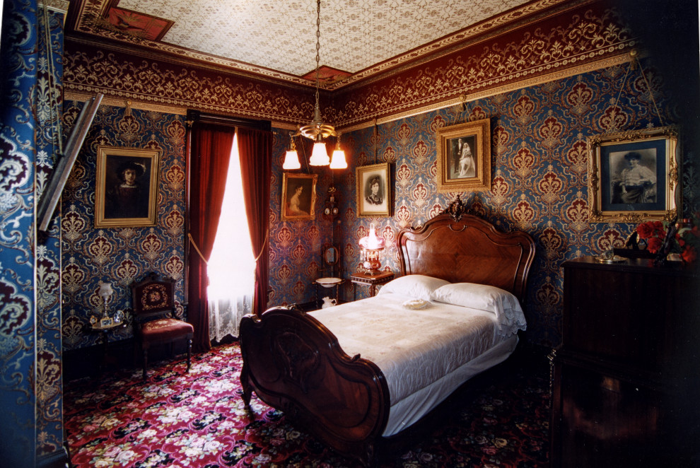Immagine di una camera degli ospiti vittoriana di medie dimensioni con moquette, soffitto in carta da parati e carta da parati
