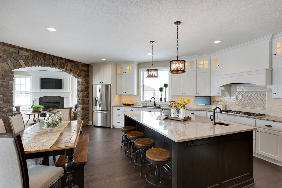 Design ideas for a traditional l-shaped eat-in kitchen in Minneapolis with an undermount sink, shaker cabinets, white cabinets, beige splashback, stainless steel appliances, dark hardwood floors and with island.