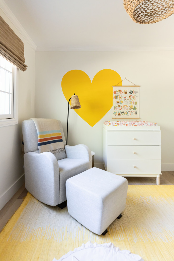 Foto de habitación de bebé neutra costera pequeña con paredes amarillas y papel pintado