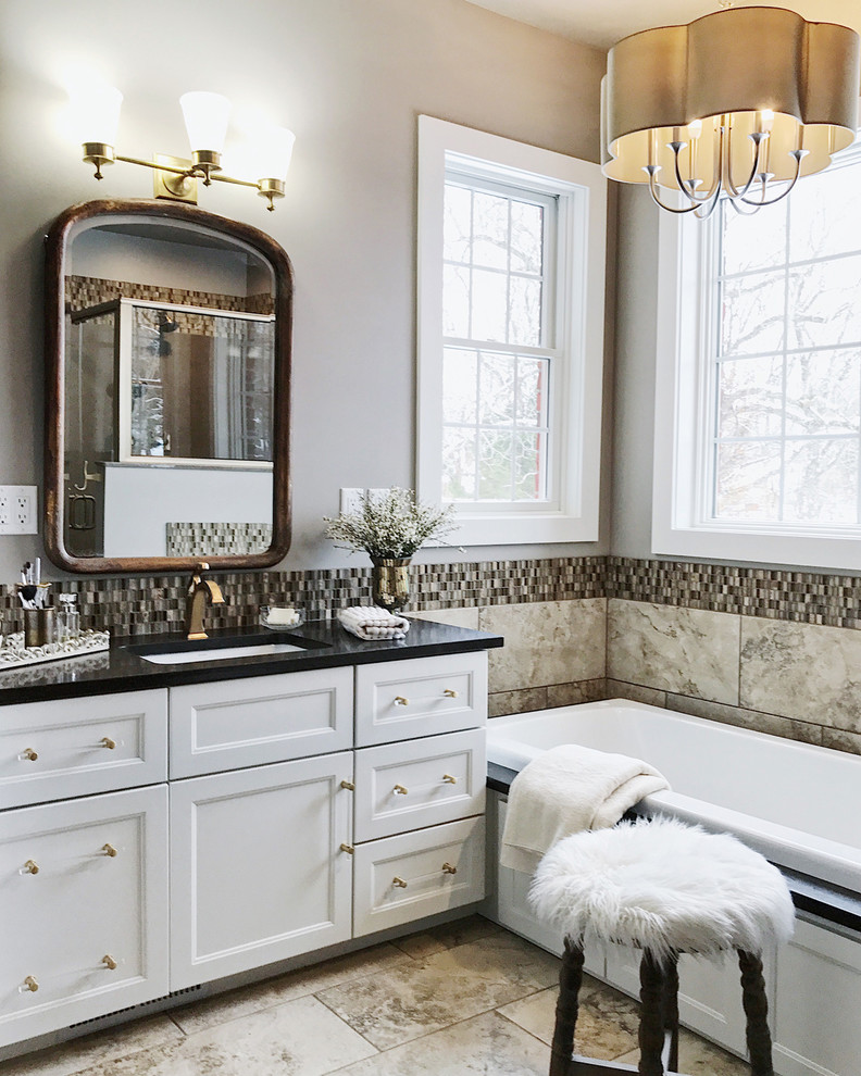 Inspiration for a mid-sized traditional master bathroom in Other with recessed-panel cabinets, white cabinets, a drop-in tub, multi-coloured tile, mosaic tile, grey walls and beige floor.