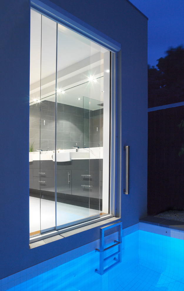 This is an example of a mid-sized contemporary master bathroom in Melbourne with a vessel sink, flat-panel cabinets, grey cabinets, marble benchtops, an open shower, a one-piece toilet, gray tile, porcelain tile, grey walls and porcelain floors.