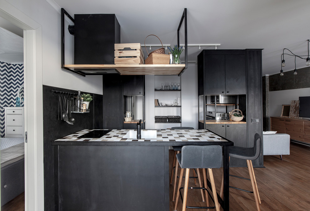 Design ideas for a small contemporary galley open plan kitchen in Other with an undermount sink, flat-panel cabinets, black splashback, medium hardwood floors and a peninsula.