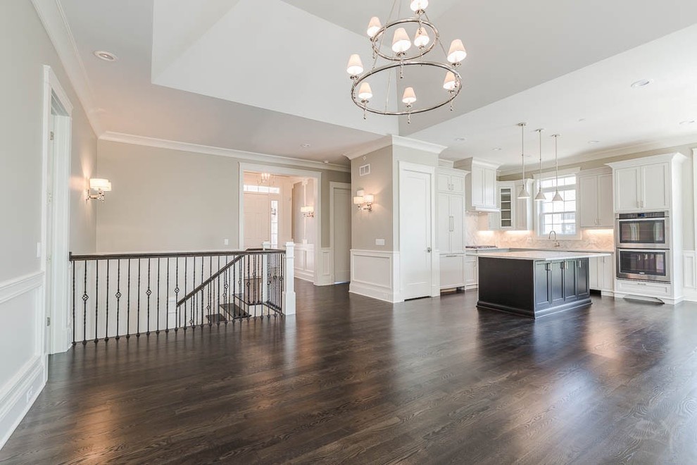 Example of a mid-sized transitional l-shaped dark wood floor eat-in kitchen design in Chicago with shaker cabinets, white cabinets, gray backsplash, stone tile backsplash, stainless steel appliances and an island