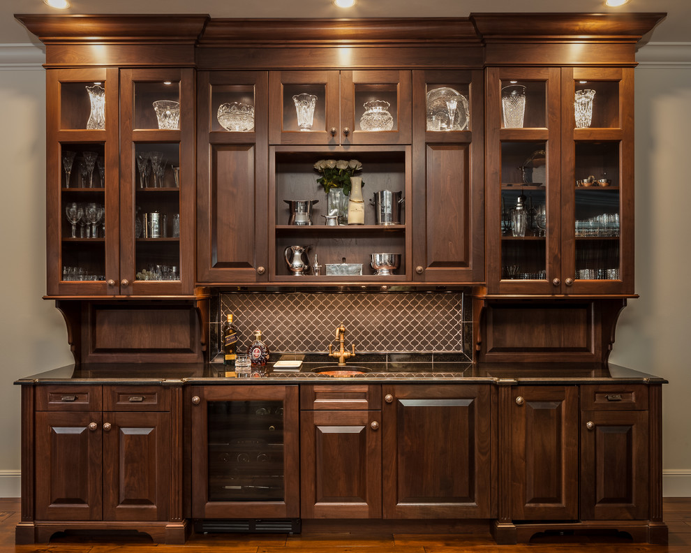 Design ideas for a mid-sized traditional single-wall wet bar in Seattle with an undermount sink, raised-panel cabinets, dark hardwood floors and dark wood cabinets.