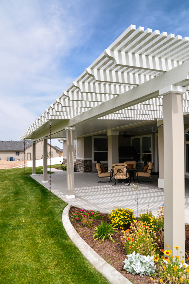 Large transitional backyard patio photo in Boise with a roof extension