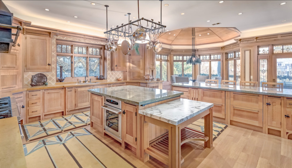 Design ideas for a large arts and crafts u-shaped eat-in kitchen in Chicago with an undermount sink, recessed-panel cabinets, light wood cabinets, beige splashback, ceramic splashback, panelled appliances, with island and multi-coloured benchtop.