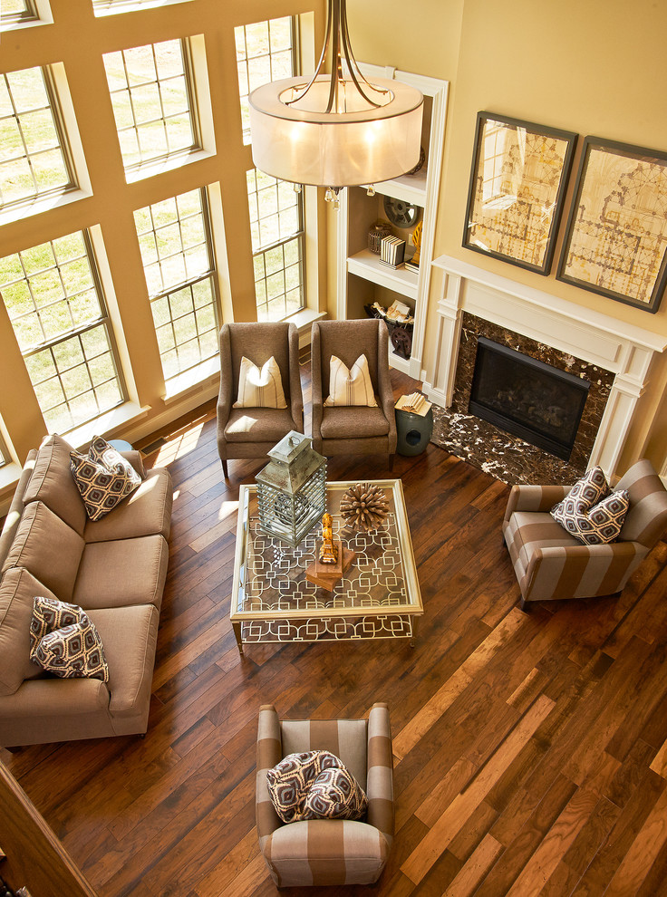Photo of a large traditional living room in St Louis with beige walls, a standard fireplace, no tv and brown floor.