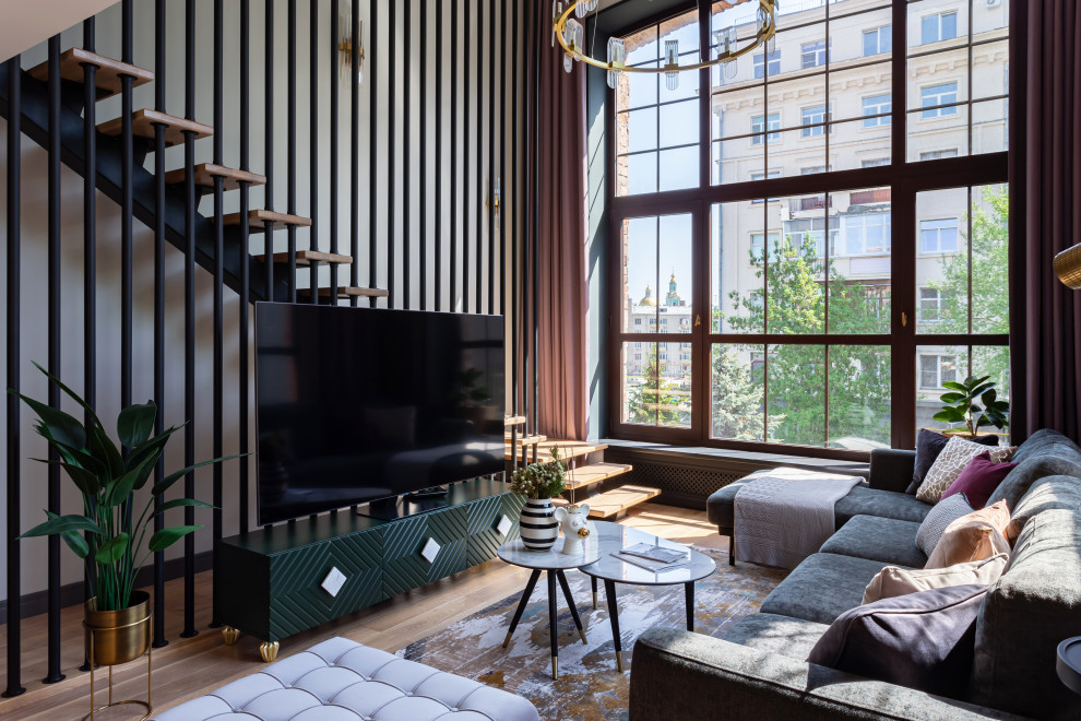 Diseño de salón contemporáneo con paredes blancas, suelo de madera en tonos medios, televisor independiente y suelo marrón