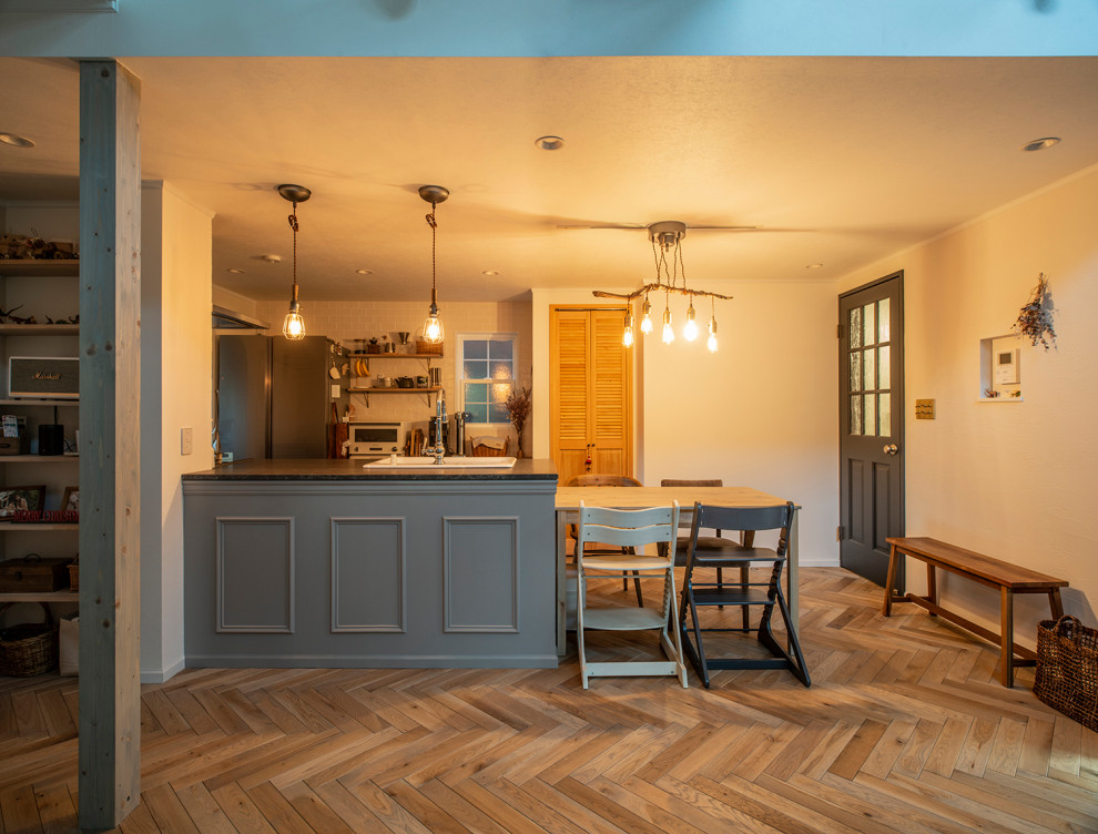 Esempio di una sala da pranzo aperta verso la cucina scandinava di medie dimensioni con parquet chiaro, pavimento grigio e pareti in perlinato
