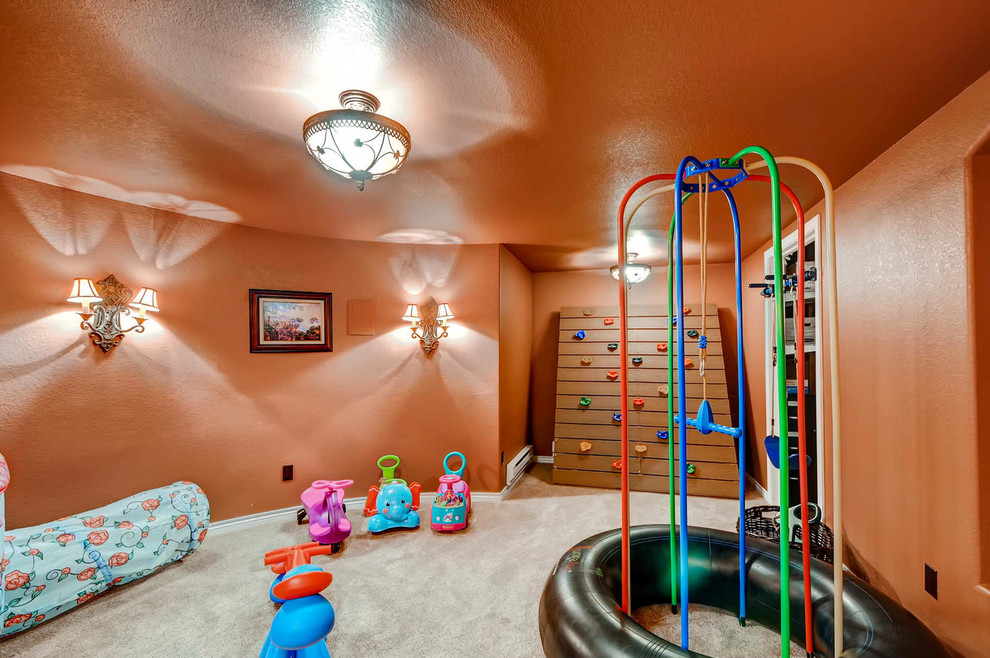 Design ideas for a mid-sized traditional gender-neutral kids' playroom for kids 4-10 years old in Denver with orange walls and carpet.
