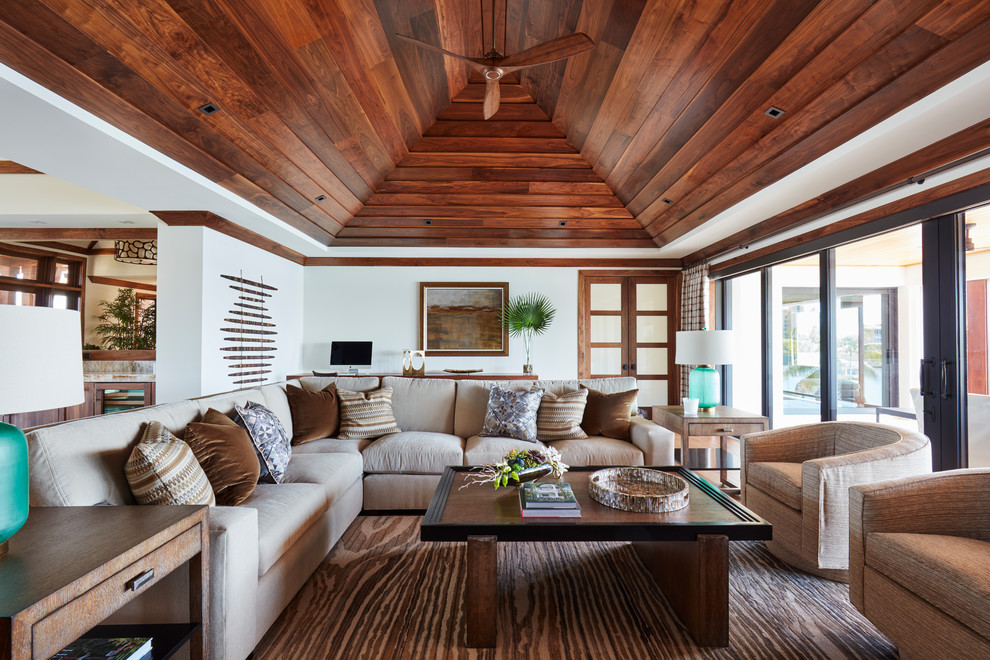 This is an example of a mid-sized tropical formal open concept living room in Miami with white walls, medium hardwood floors, no fireplace, no tv and beige floor.