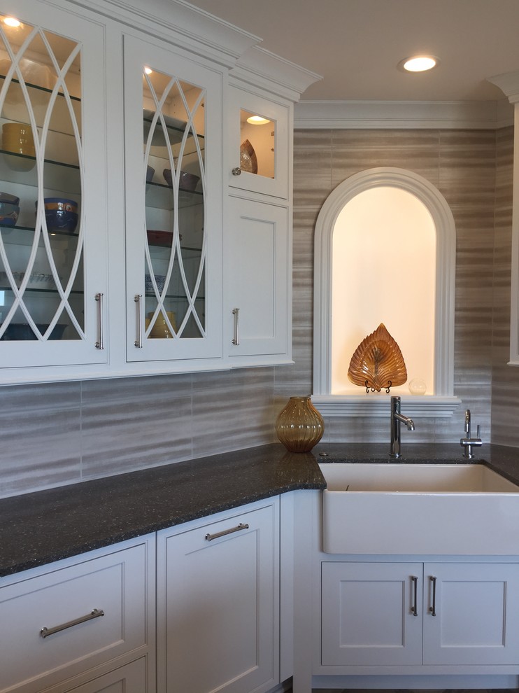 Inspiration for a large transitional ceramic tile and multicolored floor kitchen remodel with a farmhouse sink, beaded inset cabinets, white cabinets, quartz countertops, metallic backsplash, ceramic backsplash, stainless steel appliances and an island