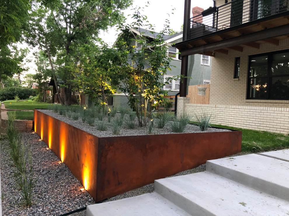 This is an example of a mid-sized modern front yard full sun garden for summer in Denver with with raised garden bed and concrete pavers.