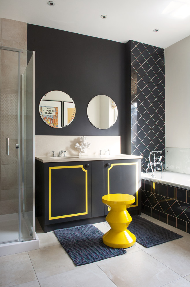 This is an example of a mid-sized transitional bathroom in London with flat-panel cabinets, a drop-in tub, grey floor, black cabinets, black walls and a hinged shower door.