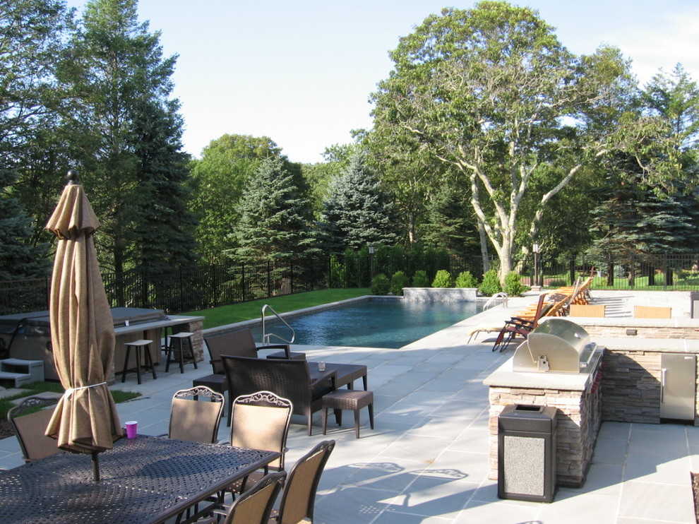 Design ideas for a traditional backyard custom-shaped natural pool in New York with a hot tub and natural stone pavers.