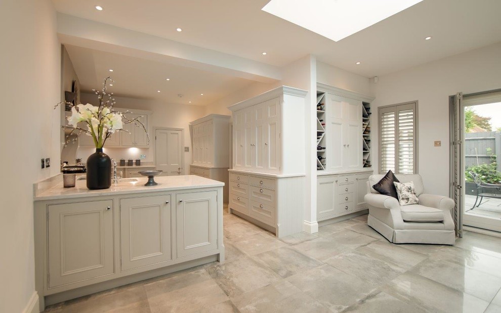This is an example of a large traditional u-shaped eat-in kitchen in Hertfordshire with an integrated sink, beaded inset cabinets, grey cabinets, quartzite benchtops, grey splashback, ceramic splashback, white appliances, ceramic floors, no island and grey floor.