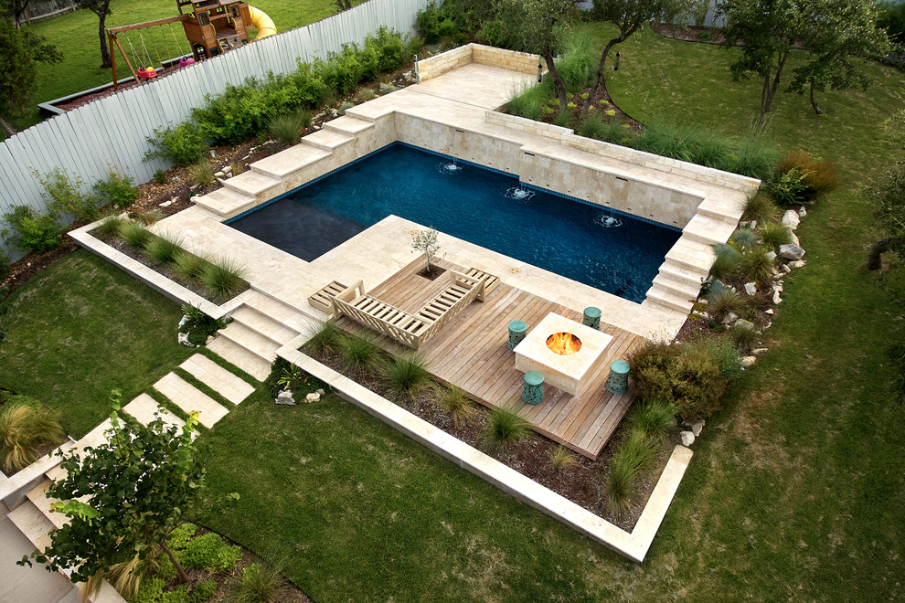 Design ideas for a mid-sized contemporary backyard l-shaped natural pool in Austin with natural stone pavers.