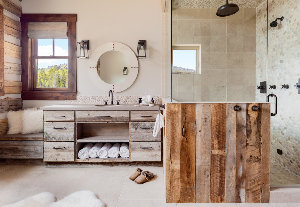 Inspiration for a country master bathroom in Other with open cabinets, light wood cabinets, a corner shower, beige tile, pebble tile, beige walls and a hinged shower door.