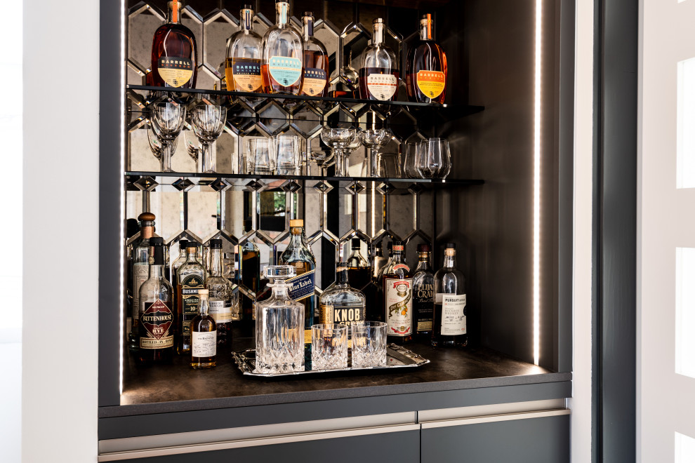 Modelo de bar en casa lineal minimalista pequeño con armarios con paneles lisos, salpicadero con efecto espejo y puertas de armario negras