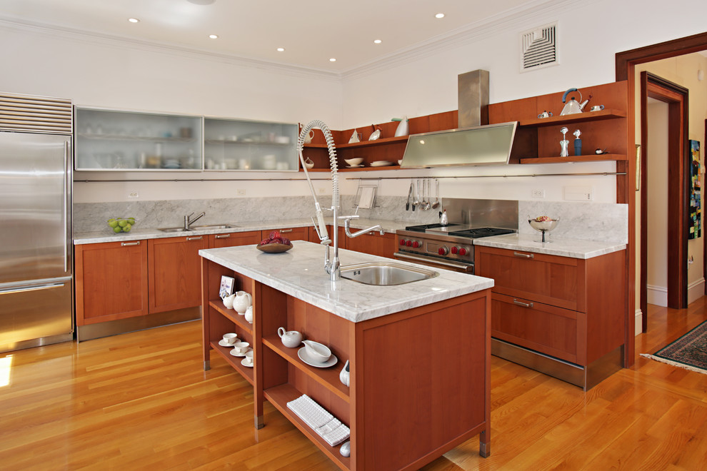 This is an example of a contemporary l-shaped kitchen in Boston with a drop-in sink, open cabinets, grey splashback, stainless steel appliances, medium hardwood floors, with island and medium wood cabinets.