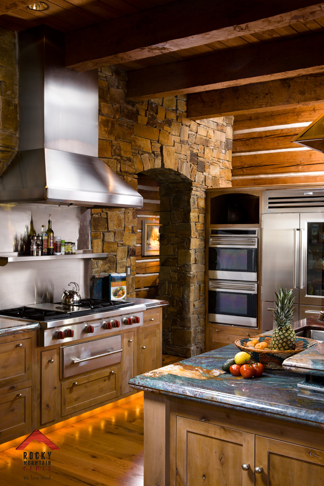 Example of a mid-sized mountain style l-shaped light wood floor kitchen pantry design with light wood cabinets, granite countertops, stainless steel appliances and an island