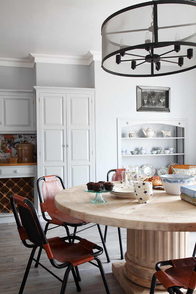Inspiration for a mid-sized country dining room in London with grey floor, grey walls and medium hardwood floors.