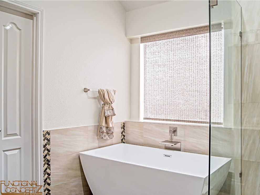 This is an example of a mid-sized contemporary master bathroom in Dallas with shaker cabinets, dark wood cabinets, a freestanding tub, beige tile, porcelain tile, porcelain floors, marble benchtops and a hinged shower door.