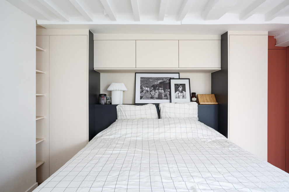Ejemplo de dormitorio principal industrial de tamaño medio con vigas vistas y paredes blancas