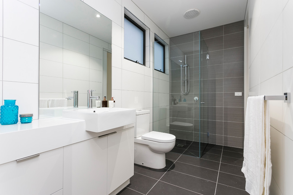 Design ideas for a small contemporary kids bathroom in Melbourne with furniture-like cabinets, white cabinets, a corner shower, a one-piece toilet, brown tile, porcelain tile, brown walls, porcelain floors, engineered quartz benchtops, brown floor, a hinged shower door and white benchtops.