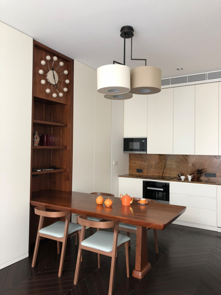 This is an example of a small contemporary single-wall eat-in kitchen in Moscow with flat-panel cabinets, beige cabinets, brown splashback, panelled appliances, no island, black floor and brown benchtop.