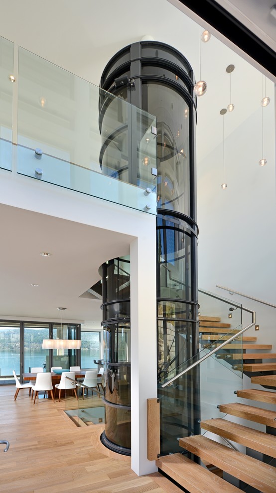 Inspiration for a contemporary wood l-shaped staircase in Vancouver with open risers and glass railing.