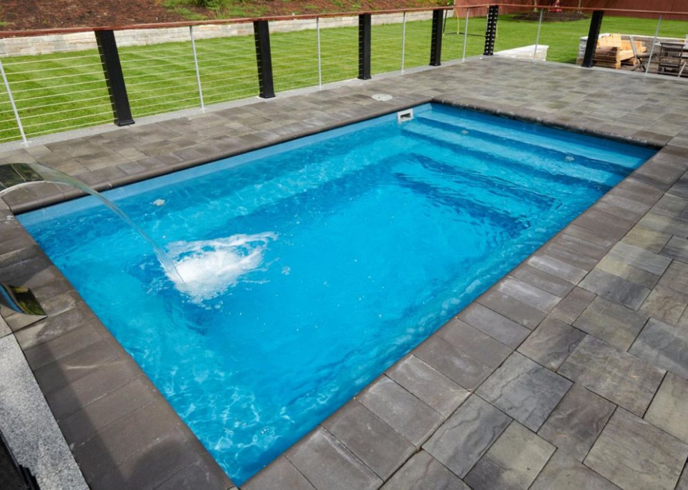 Diseño de piscina con fuente moderna pequeña rectangular en patio trasero con adoquines de ladrillo