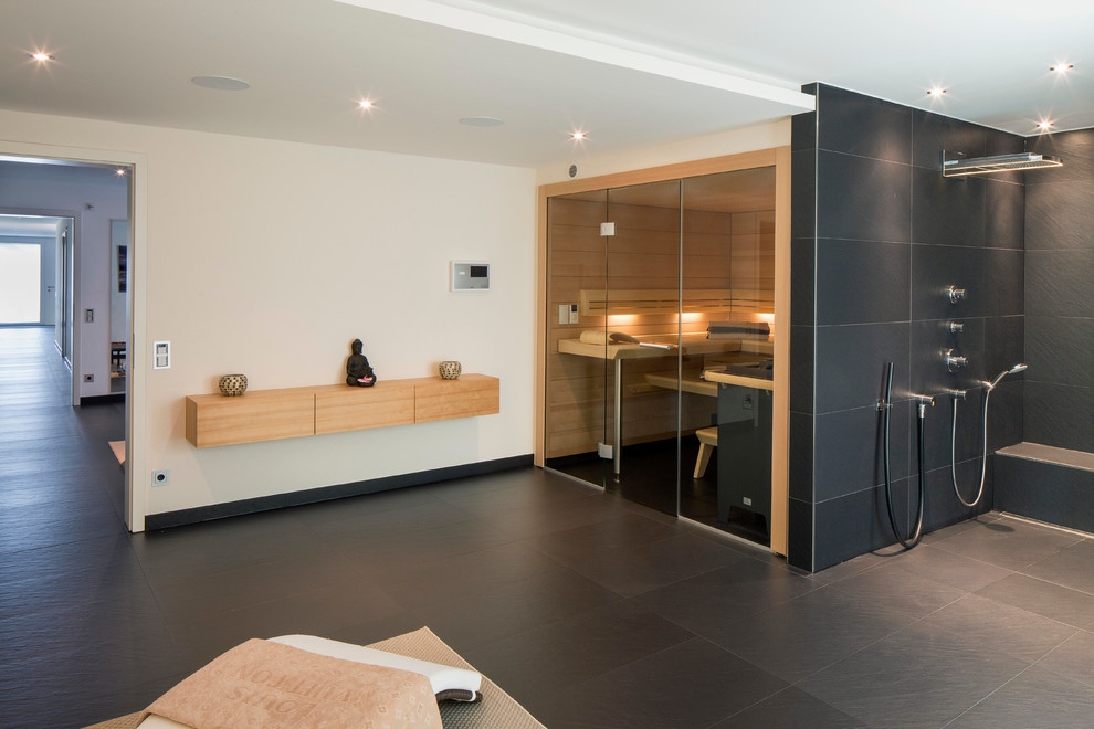 Inspiration for an expansive contemporary bathroom in Stuttgart with flat-panel cabinets, medium wood cabinets, white walls, slate floors, black tile, ceramic tile and with a sauna.