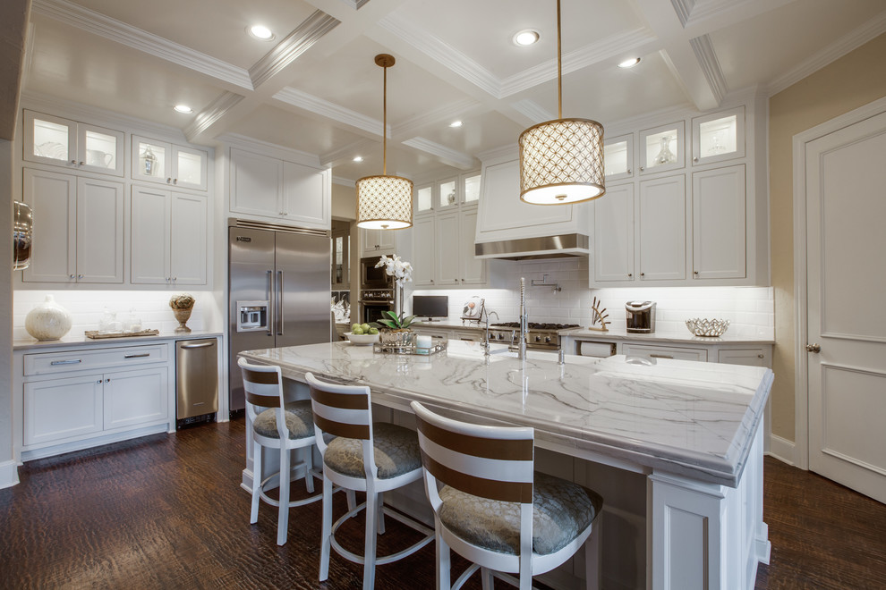 Design ideas for a large traditional kitchen in Atlanta with a farmhouse sink, shaker cabinets, white cabinets, white splashback, subway tile splashback, stainless steel appliances and dark hardwood floors.
