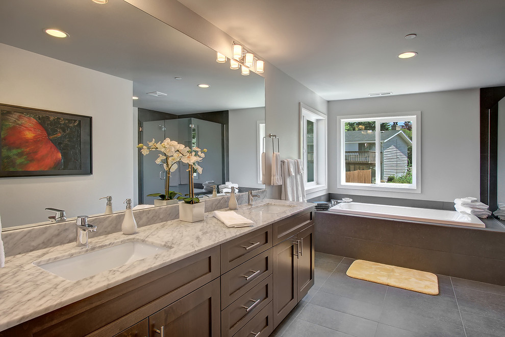 Example of a huge transitional master gray tile and ceramic tile porcelain tile drop-in bathtub design in Seattle with an undermount sink, shaker cabinets, dark wood cabinets, marble countertops, a two-piece toilet and gray walls