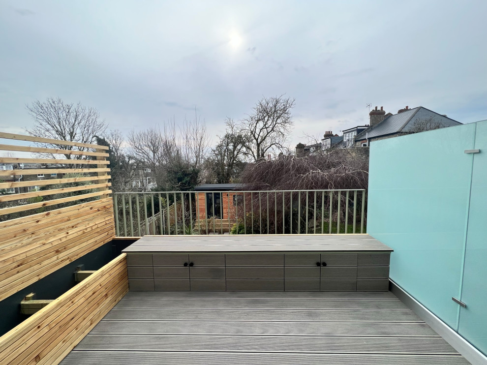 Medium sized bohemian private mixed railing balcony in London with a roof extension.