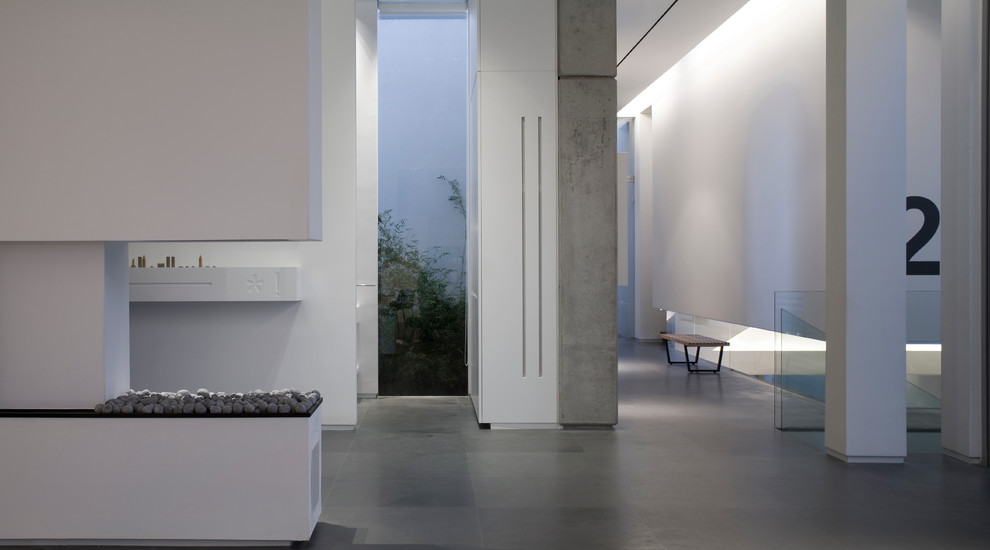 This is an example of a large contemporary hallway in Other with white walls and grey floor.