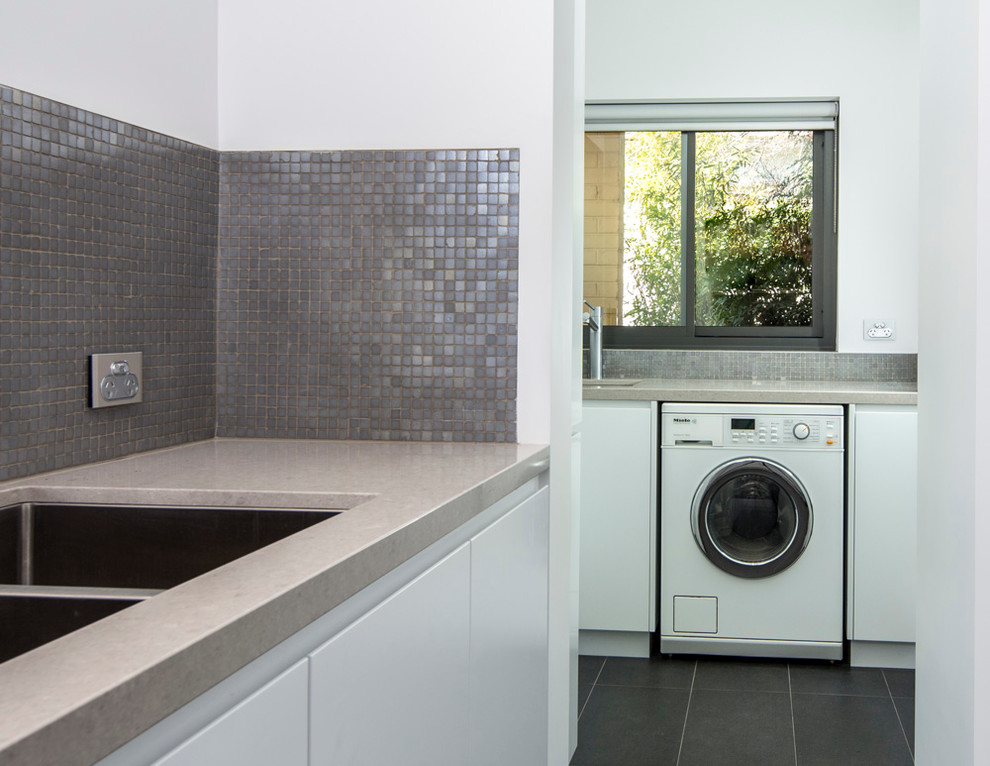 Photo of a mid-sized scandinavian l-shaped separate kitchen in Brisbane with an undermount sink, flat-panel cabinets, white cabinets, quartz benchtops, metallic splashback, mosaic tile splashback, stainless steel appliances and porcelain floors.
